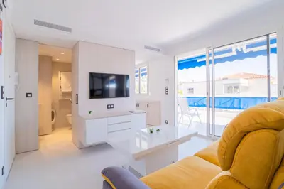a living room with a couch and a tv at 1-Br Apartment Sea View Terrace & Parking in Cannes