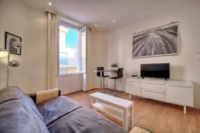 a living room with a couch and a tv at IMMOGROOM - Cosy Studio - Forville market - AC in Cannes