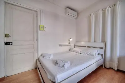 a white bedroom with a white bed and a door at IMMOGROOM - Cosy Studio - Forville market - AC in Cannes