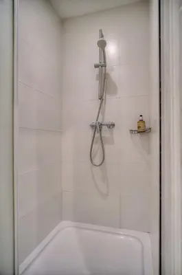 a white bathroom with a shower with a tub at IMMOGROOM - Cosy Studio - Forville market - AC in Cannes