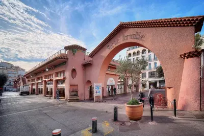a pink building with an arch on a city street at IMMOGROOM - Cosy Studio - Forville market - AC in Cannes