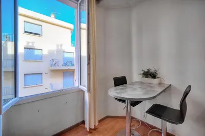a small table and chairs in a room with a window at IMMOGROOM - Cosy Studio - Forville market - AC in Cannes