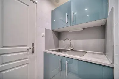 a kitchen with blue cabinets and a sink at IMMOGROOM - Cosy Studio - Forville market - AC in Cannes