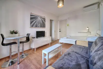 a living room with a couch and a bed at IMMOGROOM - Cosy Studio - Forville market - AC in Cannes