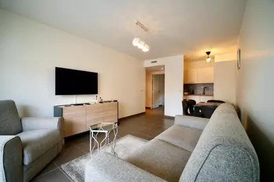 a living room with two couches and a flat screen tv at Apartment Montaigne in Cannes