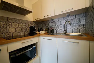a kitchen with white cabinets and a sink at Apartment Montaigne in Cannes