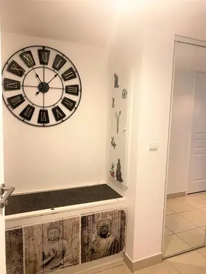 a large clock on a wall with a bench at T2 proche de la gare, à 10 minutes à pieds de la Croisette, piscine & parking dans résidence de haut standing in Cannes
