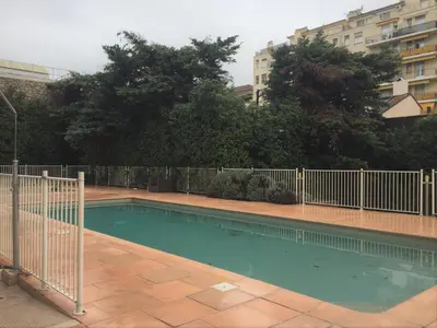a swimming pool with a fence around it at T2 proche de la gare, à 10 minutes à pieds de la Croisette, piscine & parking dans résidence de haut standing in Cannes