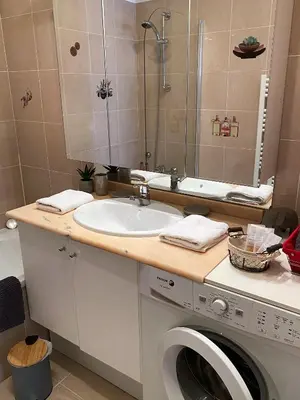 a bathroom with a sink and a washing machine at T2 proche de la gare, à 10 minutes à pieds de la Croisette, piscine & parking dans résidence de haut standing in Cannes