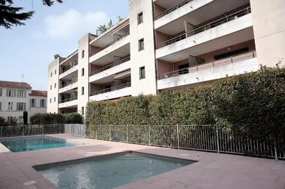 an apartment building with a swimming pool in front of it at T2 proche de la gare, à 10 minutes à pieds de la Croisette, piscine & parking dans résidence de haut standing in Cannes