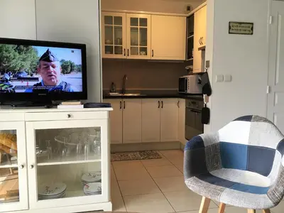 a living room with a tv and a kitchen at T2 proche de la gare, à 10 minutes à pieds de la Croisette, piscine & parking dans résidence de haut standing in Cannes