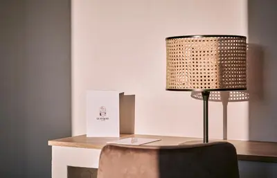 a desk with a lamp and a chair at Hotel Le Suquet Cannes in Cannes