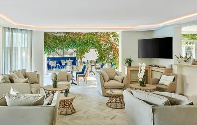 a living room with couches and a flat screen tv at Hotel Le Suquet Cannes in Cannes