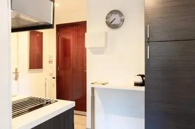 a kitchen with a refrigerator and a clock on the wall at ESCURIAL Bel appart rénové proche Croisette et plage in Cannes