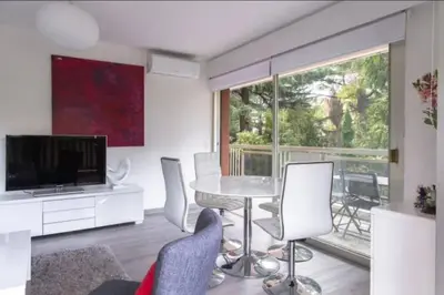 a living room with a table and chairs and a large window at ESCURIAL Bel appart rénové proche Croisette et plage in Cannes
