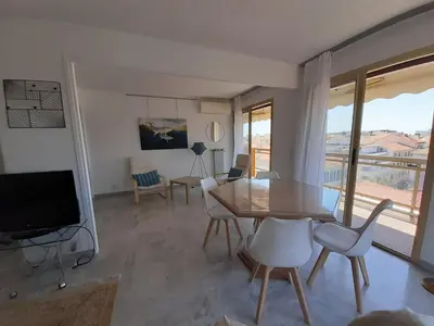 a living room with a table and chairs and a television at Le République in Cannes