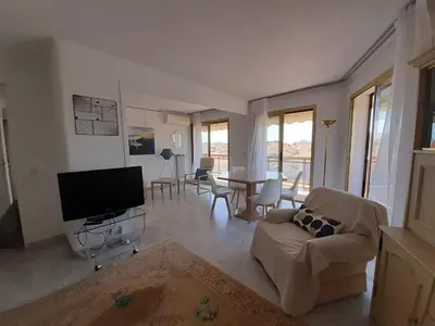 a living room with a television and a table with chairs at Le République in Cannes