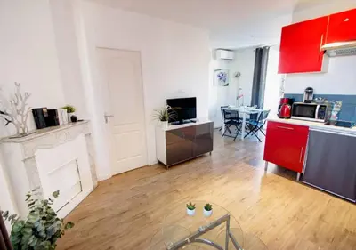 a kitchen and a living room with red cabinets at Lovely one bedroom apartment Gambetta Cannes in Cannes