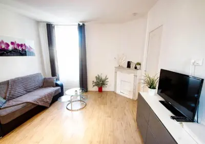 a living room with a couch and a flat screen tv at Lovely one bedroom apartment Gambetta Cannes in Cannes