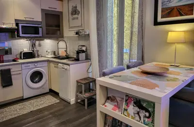 a kitchen with a washing machine and a table at Cannes apartment - city center, AC / wifi in Cannes