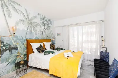 a bedroom with a large bed with a yellow blanket at Elegance in Le Cannet