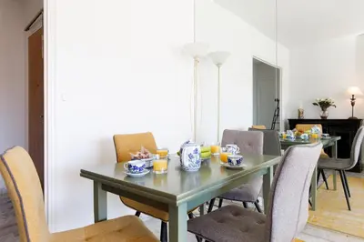 a dining room with a green table and chairs at Elegance in Le Cannet