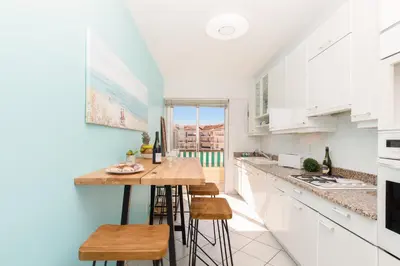 a kitchen with a table and some stools at Elegance in Le Cannet