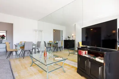 a living room with a large television and a table at Elegance in Le Cannet