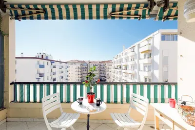 a table and chairs on a balcony with a view of buildings at Elegance in Le Cannet