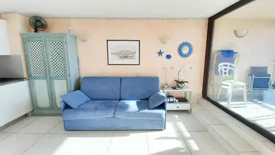 a blue couch in a living room with a mirror at Les terrasses in Cannes