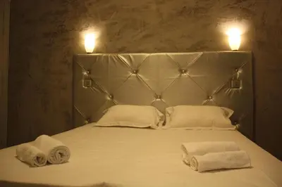 two towels on a bed with two lights on top at Arcotel** Cannes in Cannes