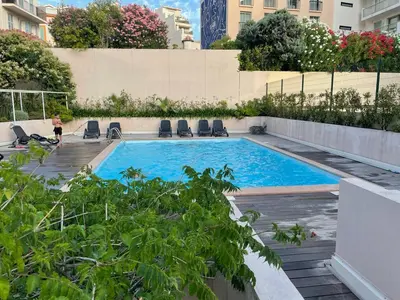a swimming pool with chairs in a building at Studio Piscine & Parking by Connexion in Cannes