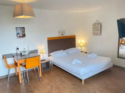 a bedroom with a bed and a table and a desk at Studio Piscine & Parking by Connexion in Cannes