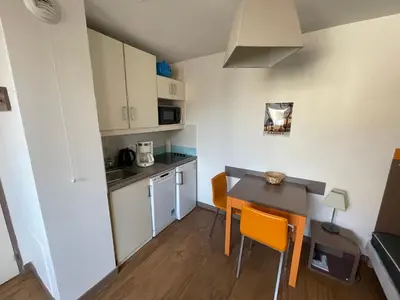a small kitchen and dining room with a table and chairs at Studio Piscine & Parking by Connexion in Cannes
