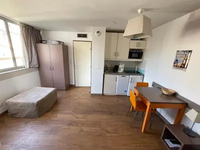 a living room with a table and a kitchen at Studio Piscine & Parking by Connexion in Cannes