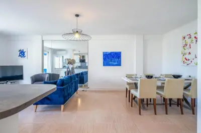 a dining room with a blue couch and a table and chairs at 2Br Apartment 100m from Beaches Terrace & Parking in Cannes