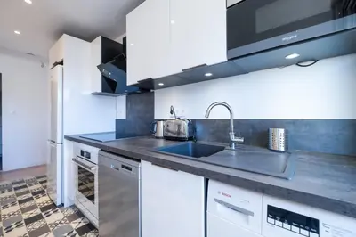 a kitchen with white cabinets and a sink at 2Br Apartment 100m from Beaches Terrace & Parking in Cannes