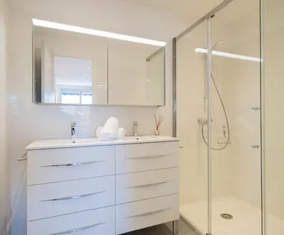 a white bathroom with a sink and a shower at 2Br Apartment 100m from Beaches Terrace & Parking in Cannes