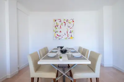 a dining room table with white chairs and a painting at 2Br Apartment 100m from Beaches Terrace & Parking in Cannes