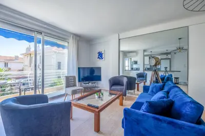 a living room with blue furniture and a large window at 2Br Apartment 100m from Beaches Terrace & Parking in Cannes