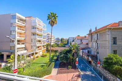 a city street with buildings and a palm tree at 2Br Apartment 100m from Beaches Terrace & Parking in Cannes