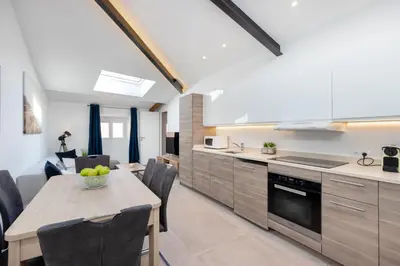 a kitchen and dining room with a table and chairs at Residence Meynadier - apartments - New - AC - Wifi - Close Beach and Palais - LRA Cannes in Cannes