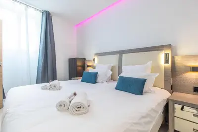 a bedroom with a large white bed with towels on it at Residence Meynadier - apartments - New - AC - Wifi - Close Beach and Palais - LRA Cannes in Cannes