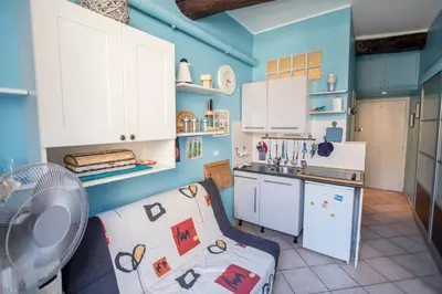 a kitchen with blue walls and a couch in a room at Le Suquet Style III by Connexion in Cannes
