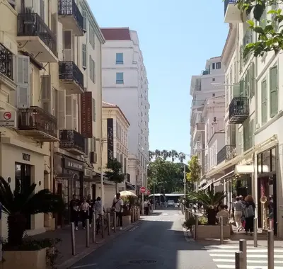 a city street with buildings and people walking down the street at Studio cosy à côté du Palais des festivals in Cannes