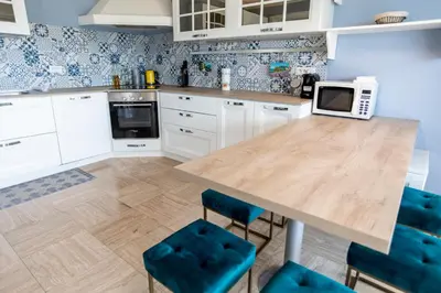 a kitchen with a wooden table with blue chairs at La Casa Blu by Connexion in Cannes