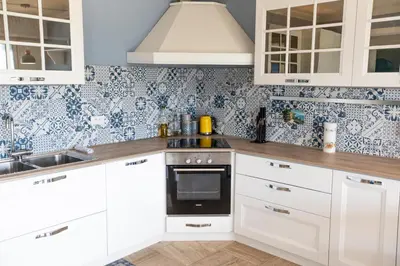 a kitchen with white cabinets and a stove top oven at La Casa Blu by Connexion in Cannes