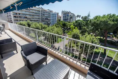 a balcony with chairs and tables and a view of a city at La Casa Blu by Connexion in Cannes