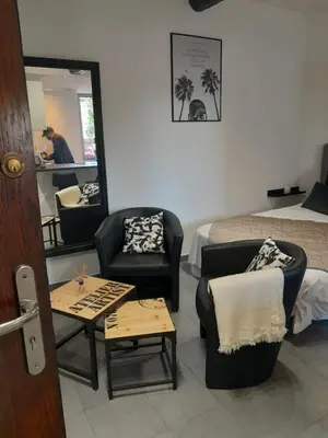 a hotel room with a bed and chairs and a mirror at FORVILLE APARTMENT Cannes in Cannes