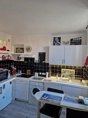 a kitchen with white cabinets and a sink and a dishwasher at Apartment Rue St Antoine in Cannes